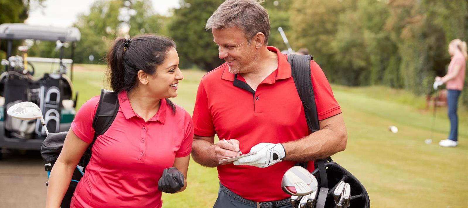 mature-couple-playing-round-of-golf-carrying-golf--LA4HSS5